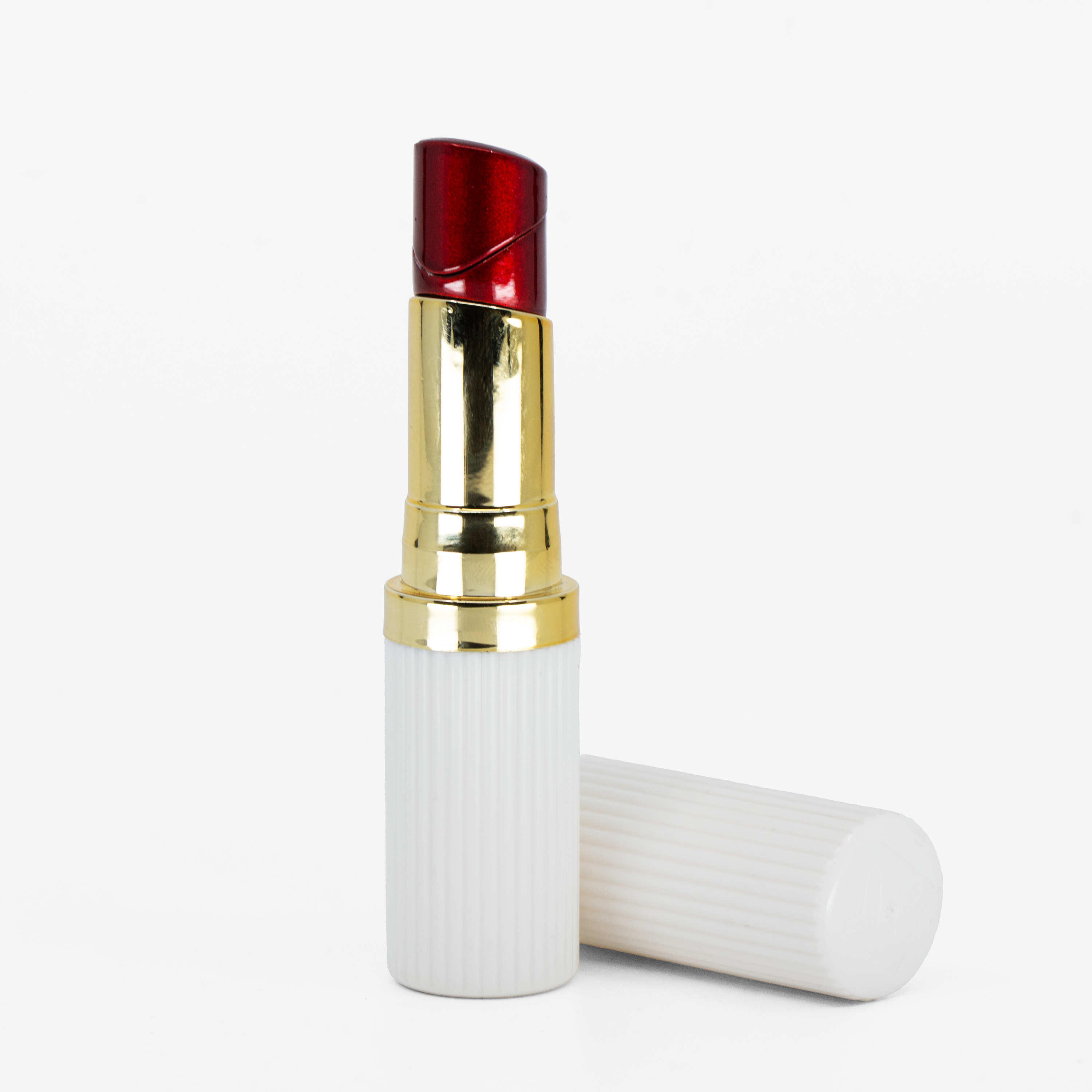 White lipstick-shaped refillable lighter with gold trim and red flame top opened and on a white background