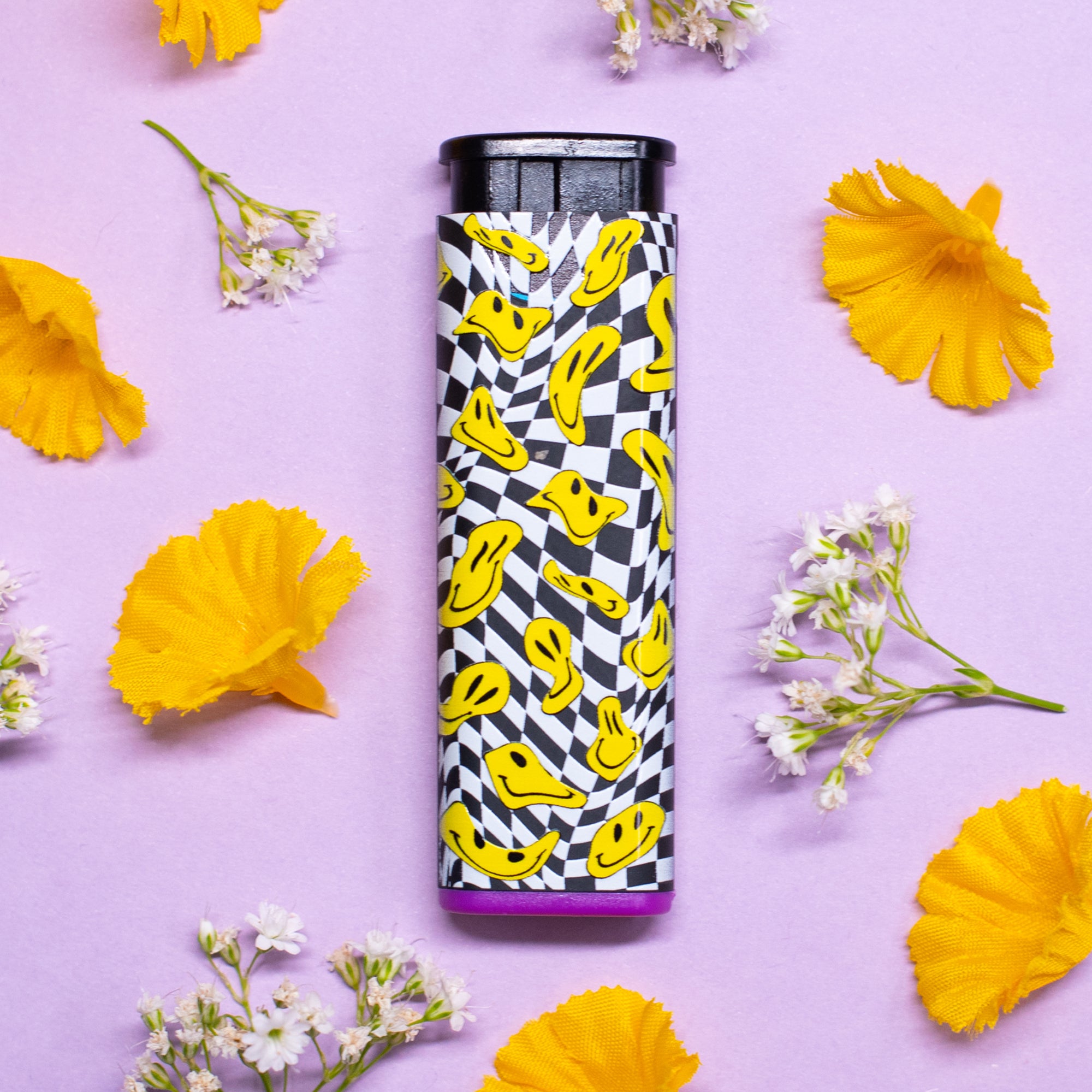 Trippy drooping yellow smiley faces on a black and white pattern torch lighter with purple accent on flower stylized background