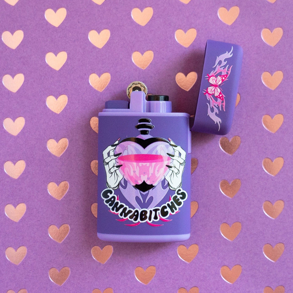 Purple flip torch lighter flipped opened with butterfly flame design and Cannabitches love potion design on a heart background