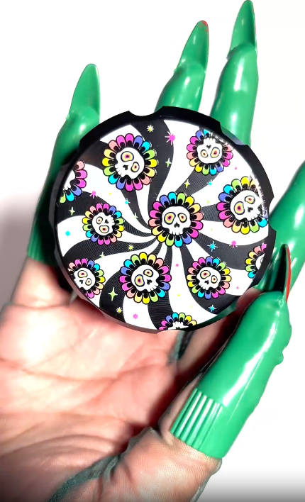 Black metal grinder with multi-color candy skull illustration on a black and white swirl design video