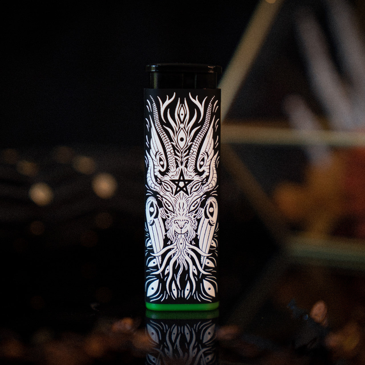 A black Baphomet Torch Lighter designed by XinaXiii with white line art of a headless figure with horns and green accent